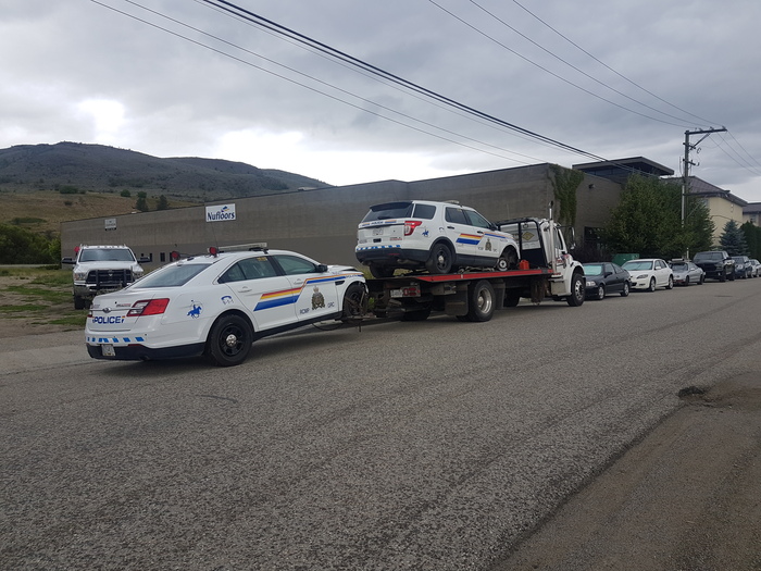 Tow truck pulling two police cars in BC