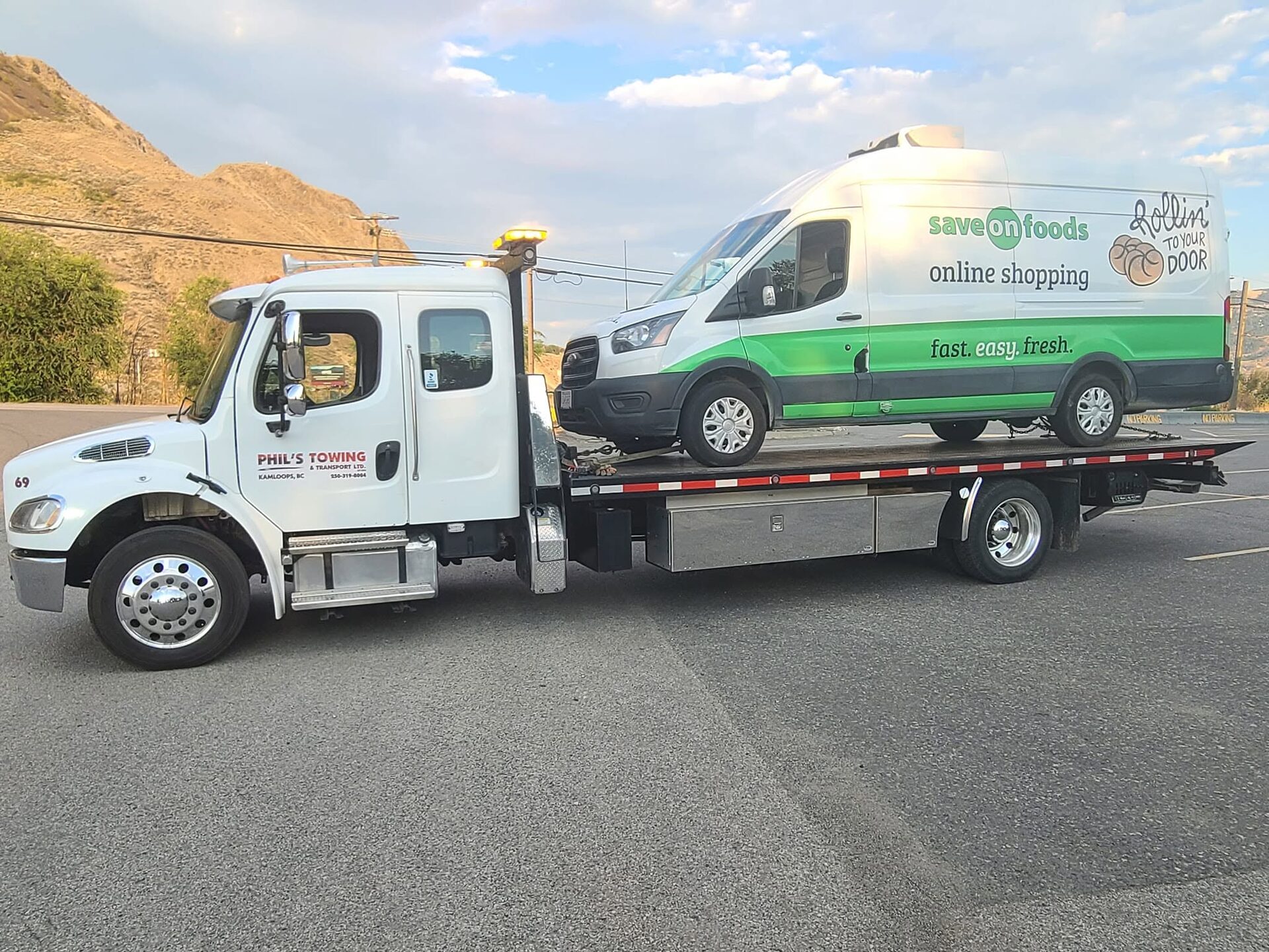 A grocery delivery van loaded on Phil's Towing flat deck