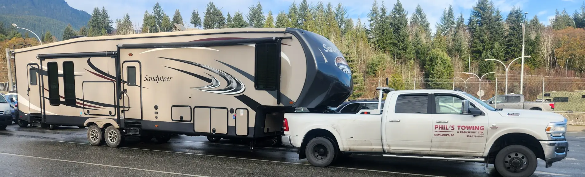 Phil's Towing hauling a 5th-wheel trailer on the highway