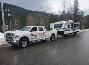 Phil's Towing hauling a 5th-wheel trailer on the highway